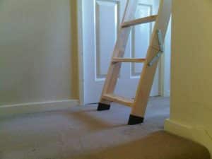Bottom of a wooden loft ladder that is fully extended